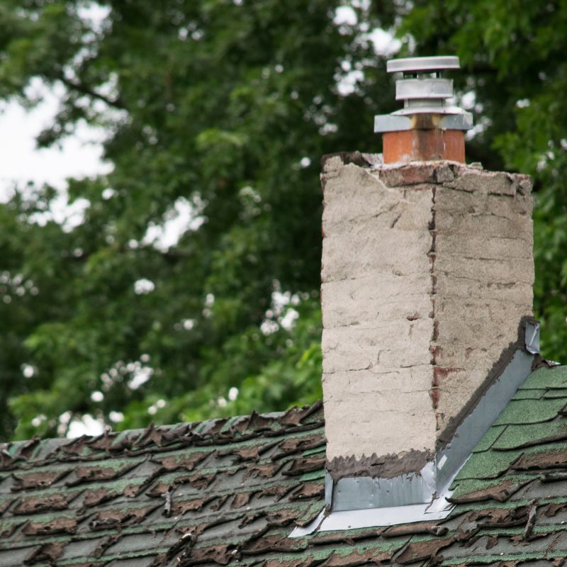 broken down masonry chimney on a damaged roof