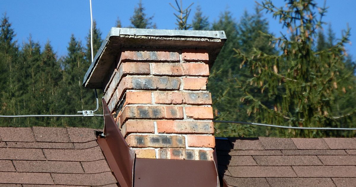 old, discolored masonry chimney with loose flashing