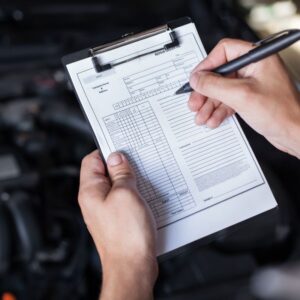 hands holding a clip board and checking off things on a repair order form