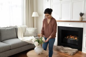 %Title% | Sureglow Stove &Amp; Chimney a woman arranging flowers on the coffee table with a fire crackling behind her